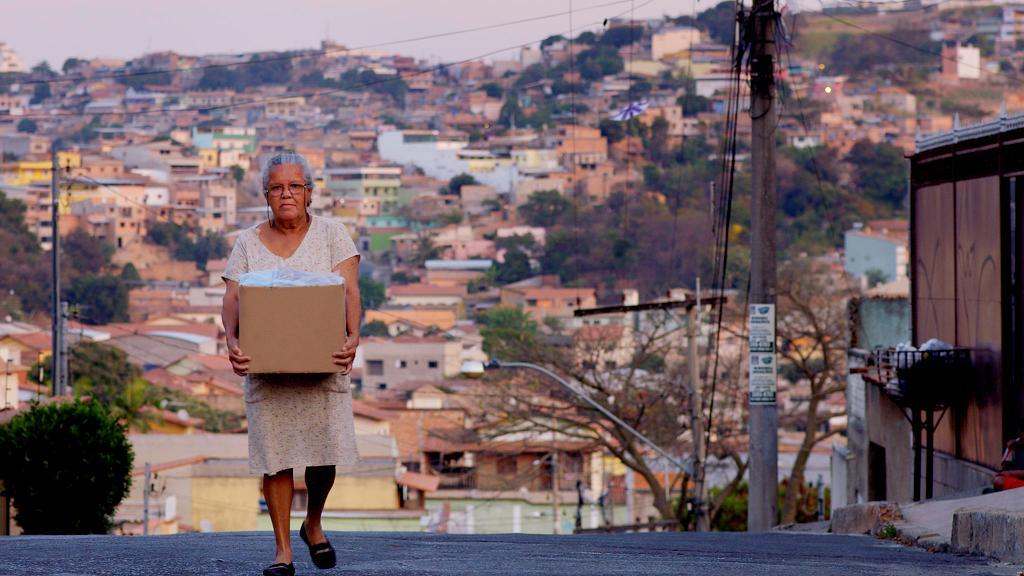 A woman carrying a box in 'In the Heart of the World'