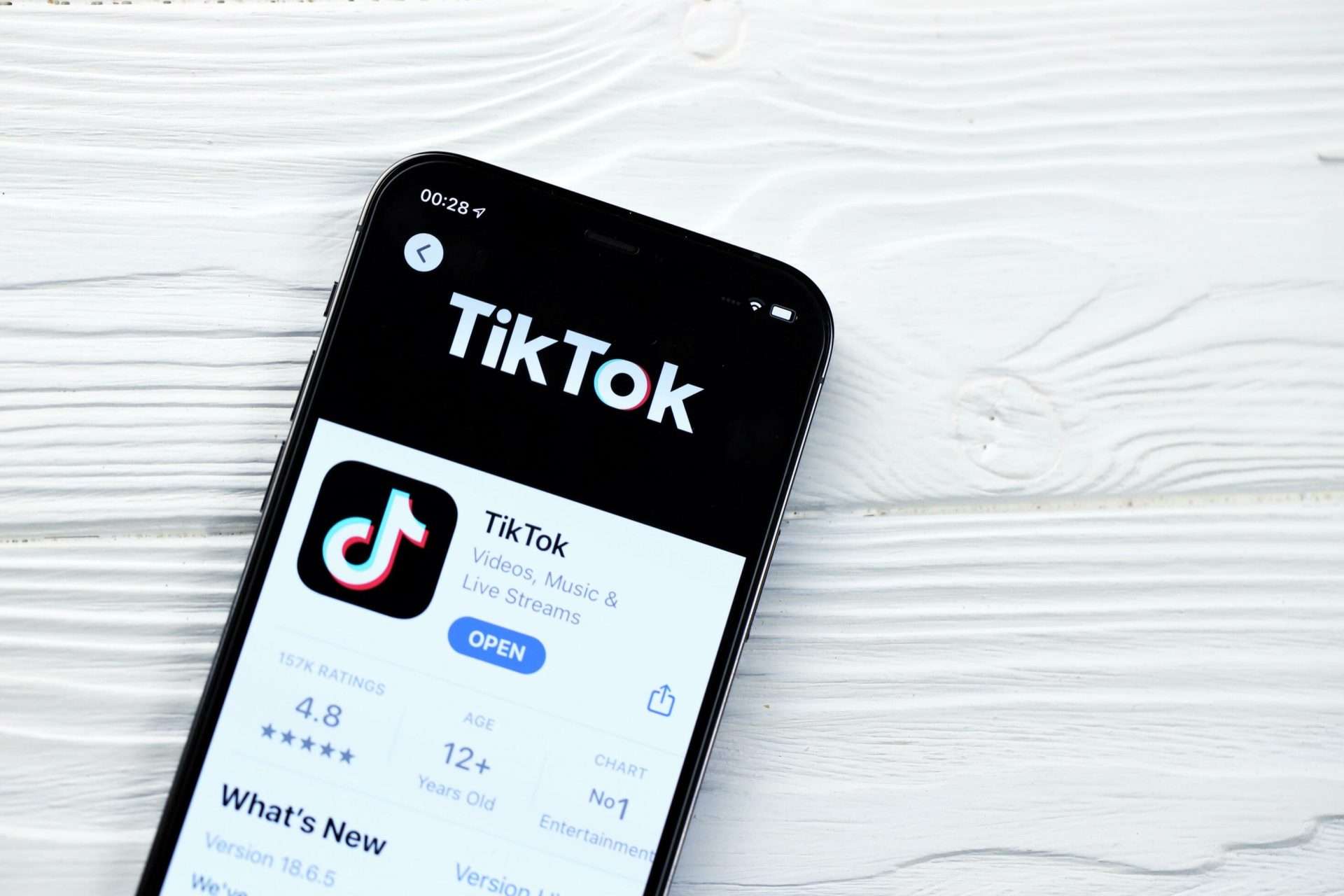 a phone with tiktok open on it, resting on a wooden table
